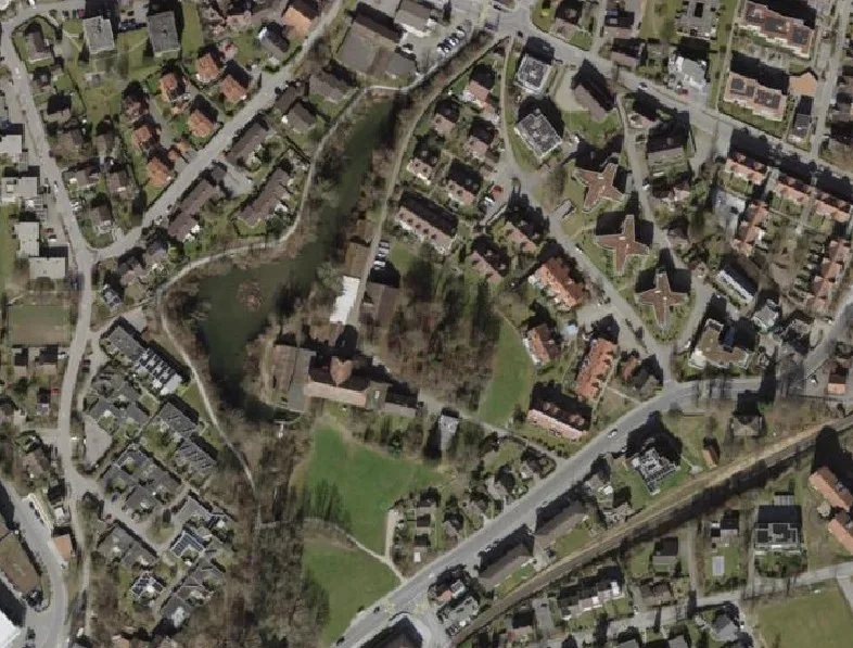 Rund um das Wäldchen in der Bildmitte werden die neuen Wohnbauten gruppiert. Luftbild des Schönau-Areals beim Schönau-Weiher in Wetzikon.